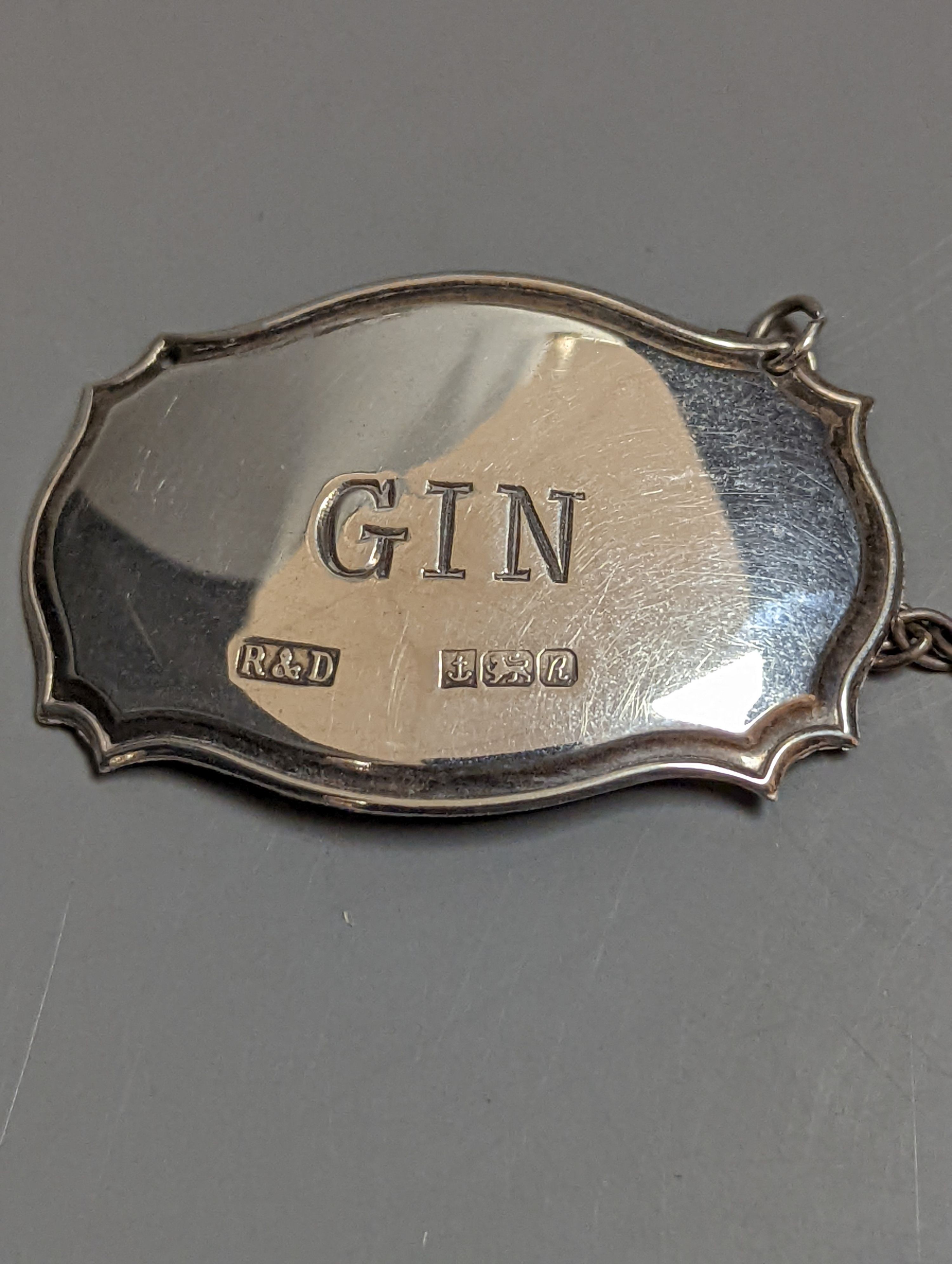 A pair of silver mounted cut glass spirit decanters and a ‘GIN’ spirit label